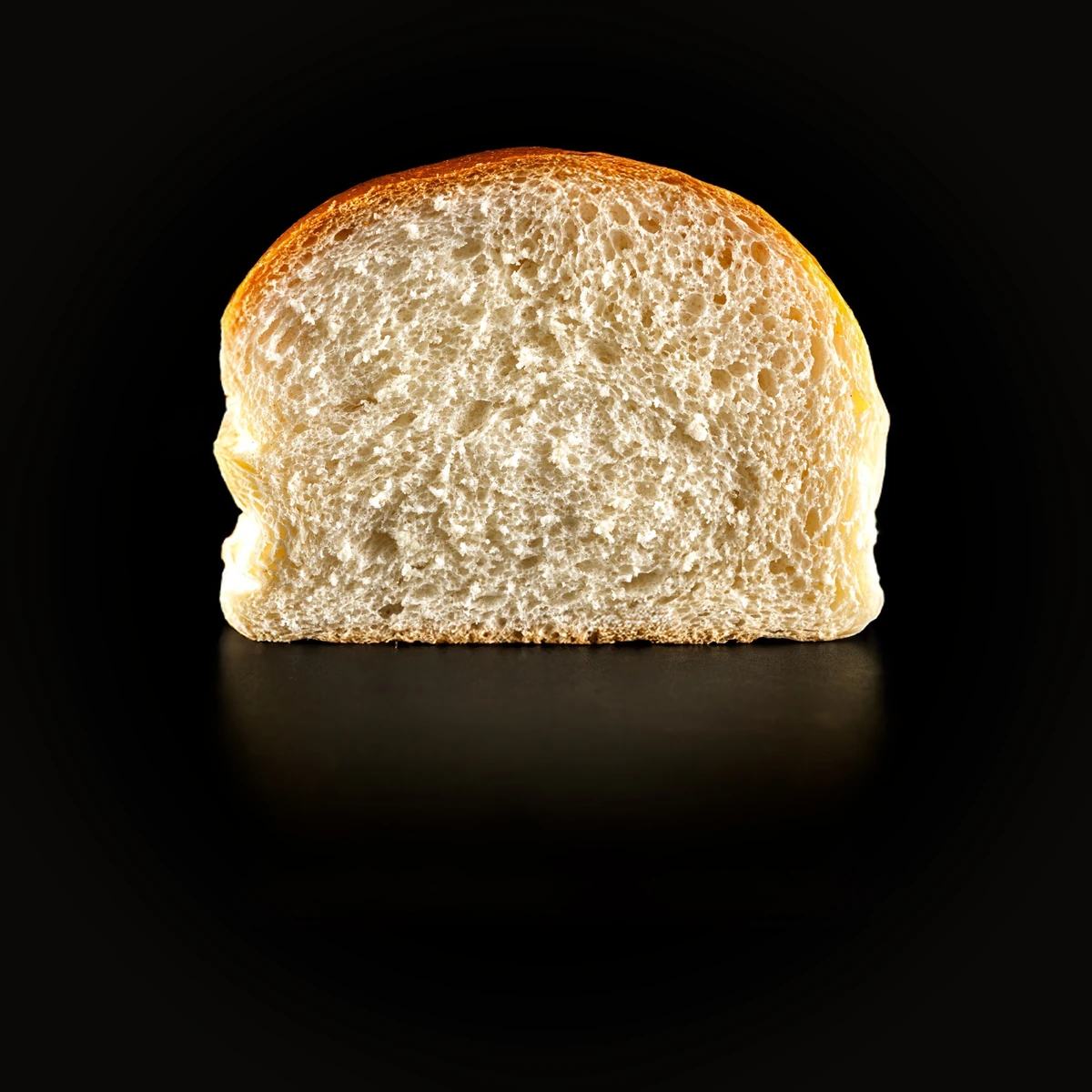 Pan brioche partido por la mitad, con la miga a la vista